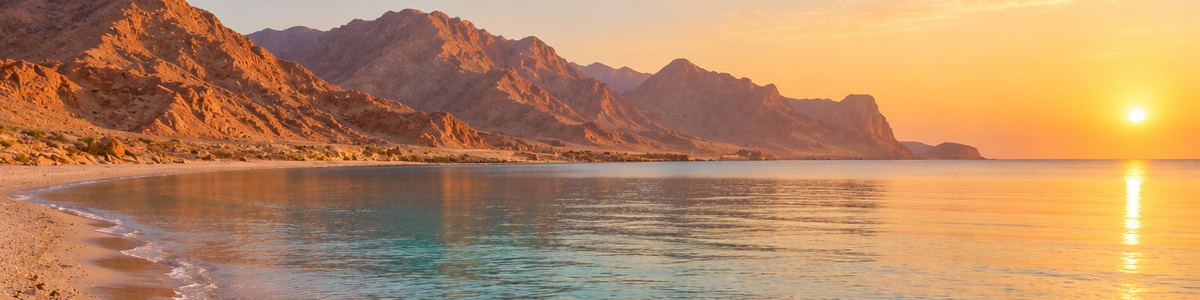 Mountains and a calm sea at sunset